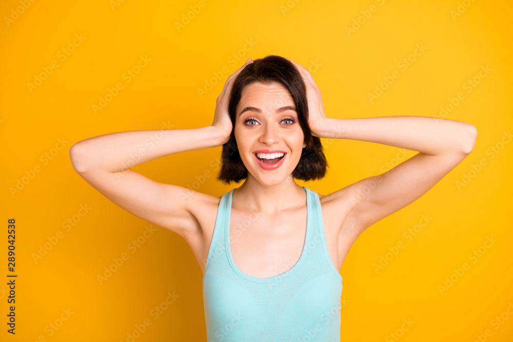 Photo of charming nice cute interesting girl surprised so much that holding head with hands while isolated with yellow background Photo of charming nice cute interesting girl surprised so much that holding head with hands while isolated with yellow background