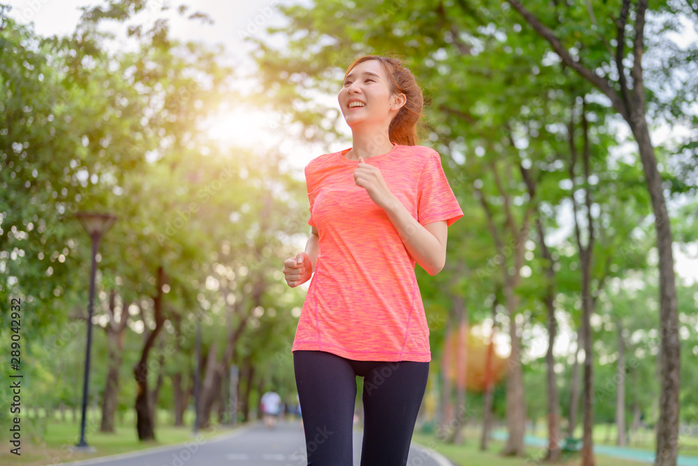young asian woman doing exercise by jogging run  in city public park