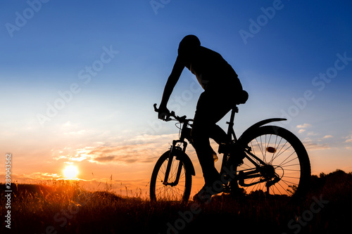 Bicycle man silhouette at sunset.