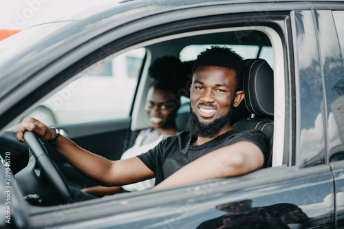 Young african couple drive car in road trip