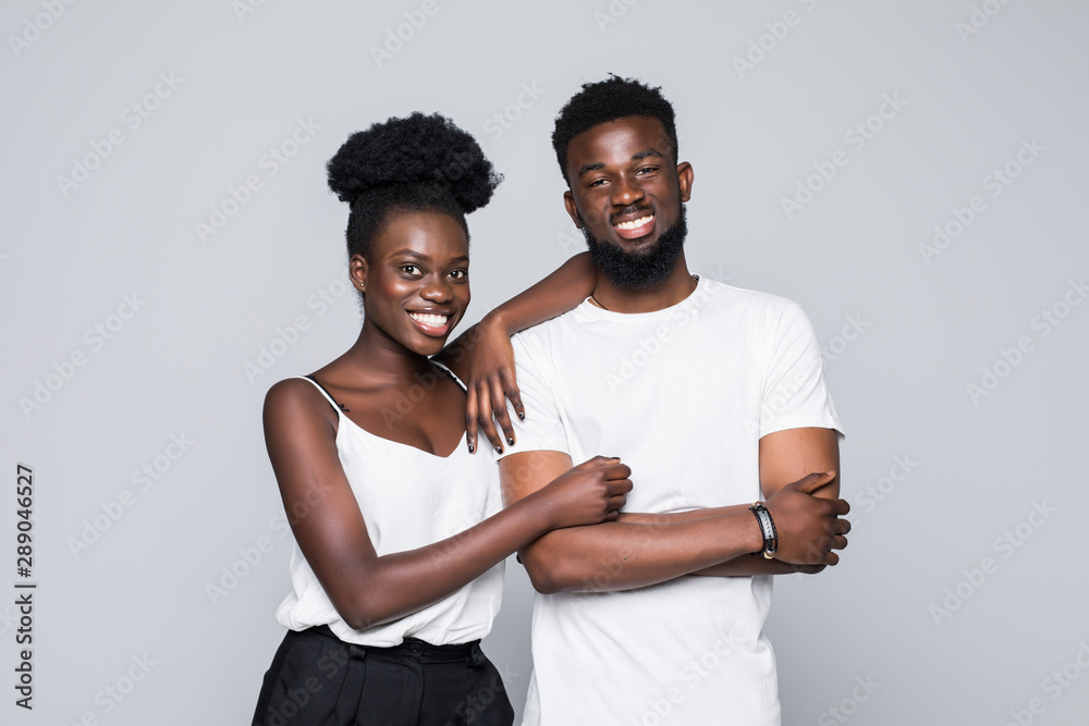 Obraz premium Young happy african couple standing isolated on gray background