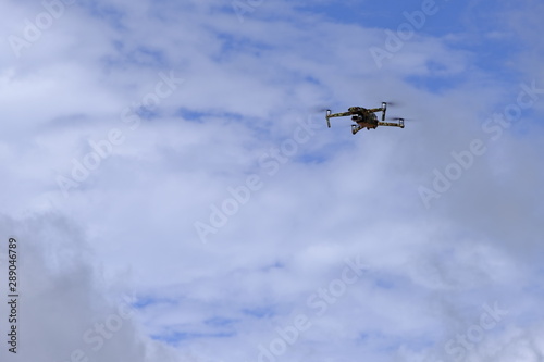 Fototapeta Naklejka Na Ścianę i Meble -  Black drone quadcopter flying on the air for take a photo and video with cloudy background.