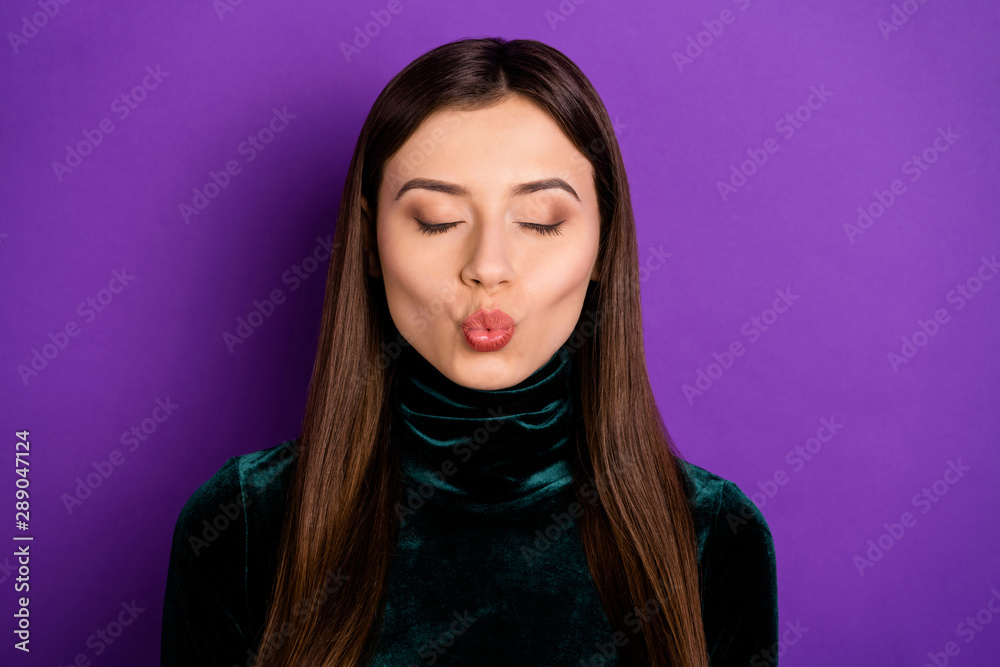 Close up photo of pretty woman with her eyes closed sending air kisses isolated over purple violet background Close up photo of pretty woman with her eyes closed sending air kisses isolated over purple violet background