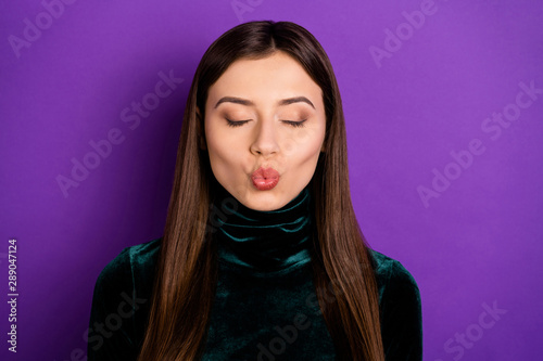 Close up photo of pretty woman with her eyes closed sending air kisses isolated over purple violet background
