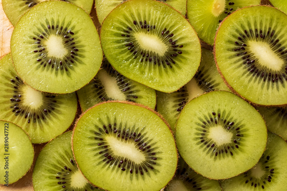 heap of fresh green kiwi slices background. top view heap of fresh green kiwi slices background. top view