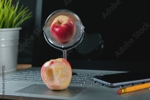 social media fakeness and cheating concept - bitten apple with perfect reflection photo