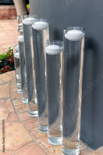 Various heights of water tubes hold outdoor floating candle decorations for the party. photo