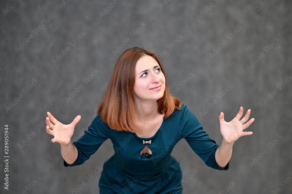 Portrait of a brunette girl with beautiful brown hair in a dark green dress on a white background. Standing in different poses, showing emotions. Portrait of a brunette girl with beautiful brown hair in a dark green dress on a white background. Standing in different poses, showing emotions.