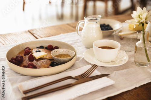 Wallpaper Mural Photo closeup of breakfast meal and cutlery. Pancakes with berries, milk, coffee on kitchen table Torontodigital.ca