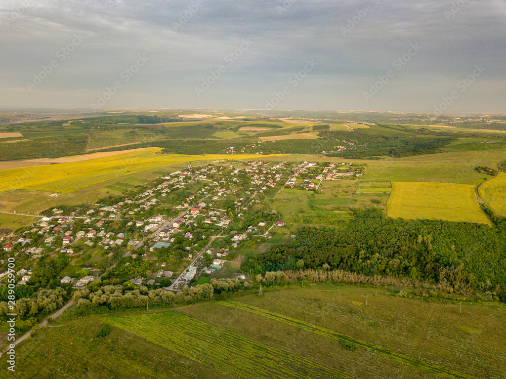 Fototapeta premium Aerial view over a small village and agricultural fields