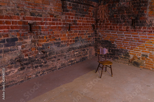 Single, old chair against old brick wall