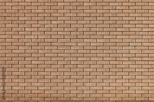 Modern new brick wall made of beautiful textured light orange brick and brown cement seam. Texture background