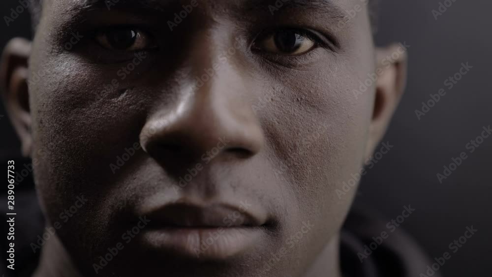 Young black african man with closed eyes,opening and looking at camera Young black african man with closed eyes,opening and looking at camera