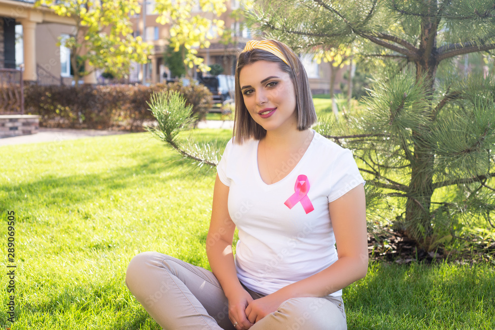 The girl holding a pink ribbon, symbol of cancer. Breast cancer awareness month. The girl holding a pink ribbon, symbol of cancer. Breast cancer awareness month.