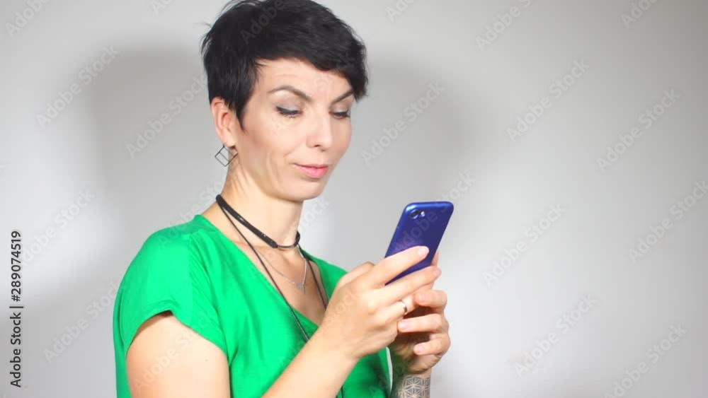 Communication during self-isolation of coronavirus infection COVID-19. Girl in a green blouse posing with a smartphone in her hands Communication during self-isolation of coronavirus infection COVID-19. Girl in a green blouse posing with a smartphone in her hands