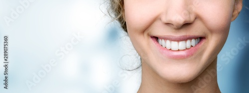 Piękny szeroki uśmiech młodej świeżej kobiety z wielkimi zdrowymi białymi zębami. Pojedynczo na tle