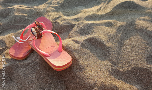 Ciabatte da spiaggia con occhiali da sole nella sabbia