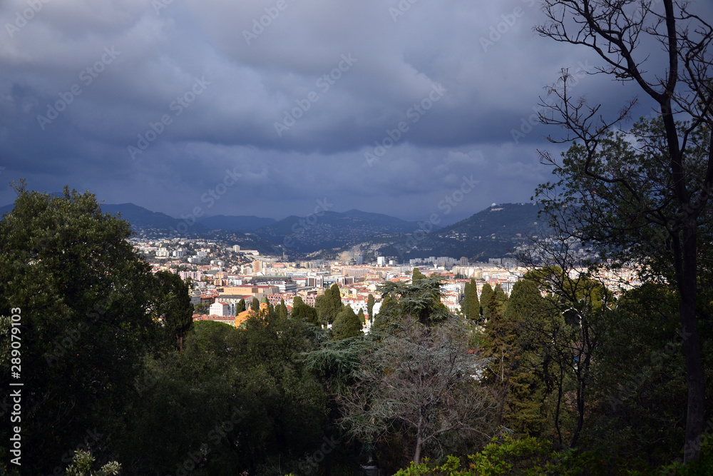 Nice, France - february 11th 2018 : cityscape of Nice during a thunderstorm with some vegetation.