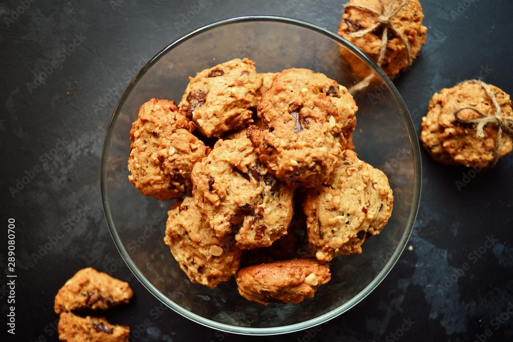 Oatmeal cookies with chocolate. Cookies on a black table background, isolated. A stack of cookies with cords. Oatmeal cookies with chocolate. Cookies on a black table background, isolated. A stack of cookies with cords.