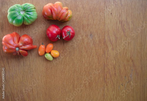 Fototapeta Naklejka Na Ścianę i Meble -  Tomatoes on a wooden background. Top view. Free space for text.