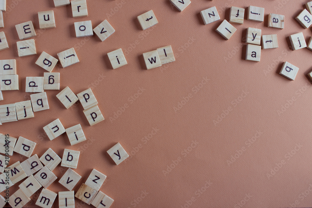 Random wooden letters on coral background