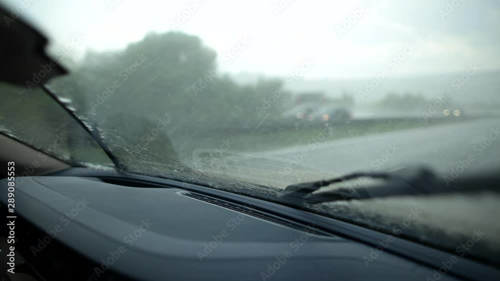 Caucasian Men Driving Modern Car During Heavy Thunderstorm with Rainfall. Transportation Industry. Vehicle Windshield. Caucasian Men Driving Modern Car During Heavy Thunderstorm with Rainfall. Transportation Industry. Vehicle Windshield.