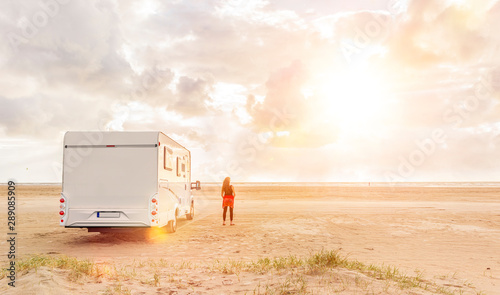 Wohnmobil mit Frau am Srtand