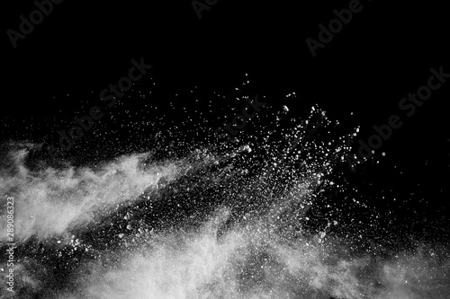 White powder explosion isolated on black background. White dust particles splash. photo