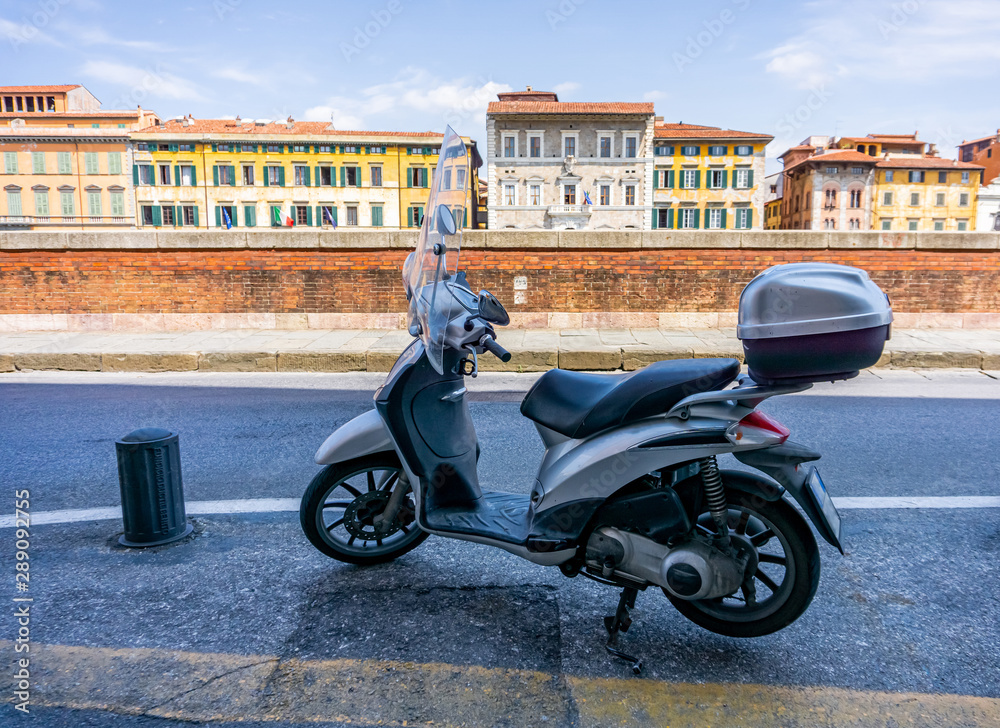 View of the street with scooter and beautiful buildings in Pisa,Tuscany, Italy