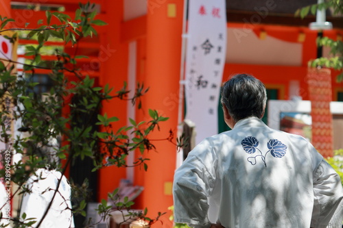 京都、上賀茂神社の楼門前の令和ののぼり旗を見る法被を着た男性の後ろ姿 © 眞