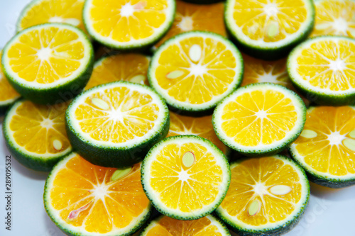 round slices of natural fresh tangerines, oranges, lemon, lime with green peel