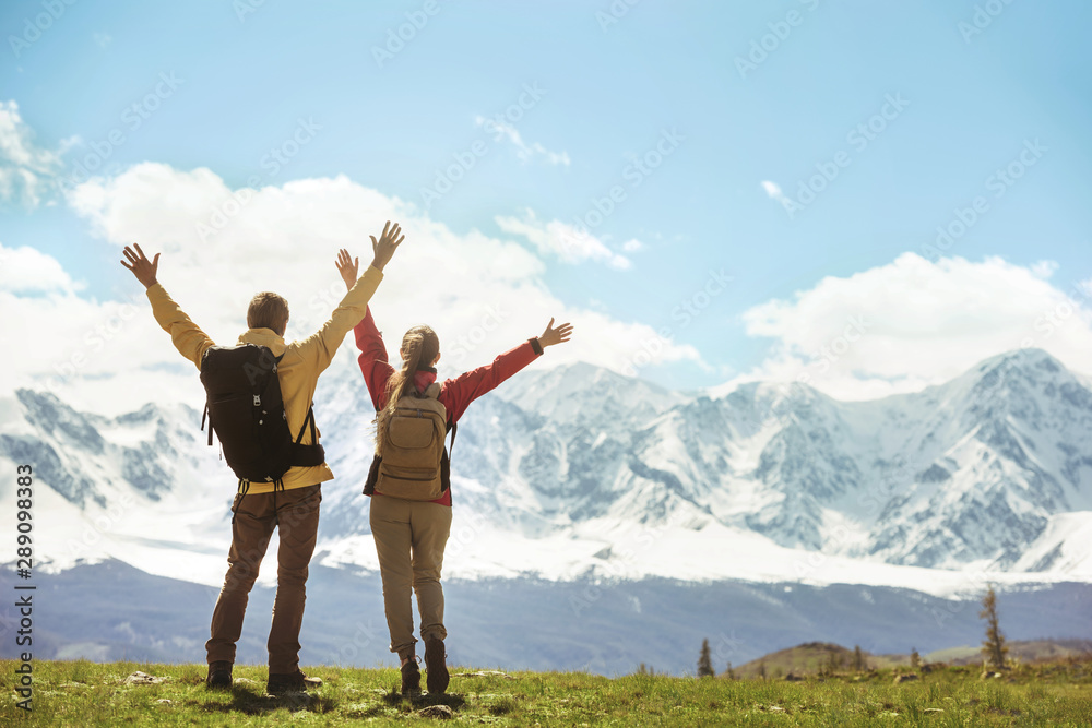 Two successful hikers against white mountains Two successful hikers against white mountains