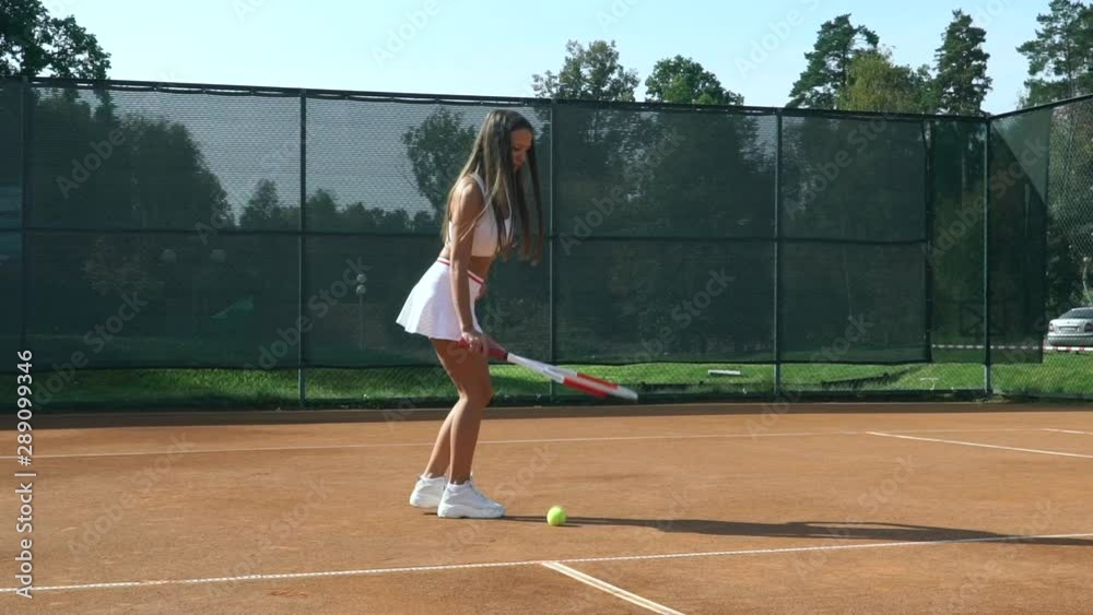 Girl tennis player training on the court with a racket and a ball. Girl tennis player training on the court with a racket and a ball.