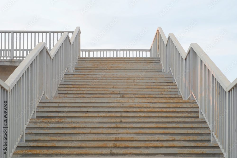 Naklejka premium Metal rusty stairs painted in grey going up.