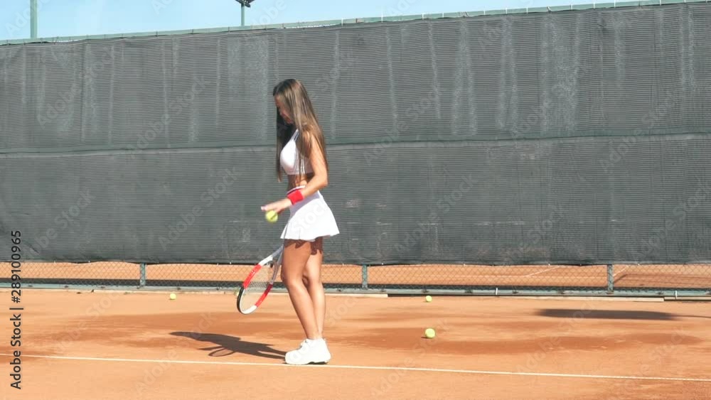 Girl tennis player training on the court with a racket and a ball. Girl tennis player training on the court with a racket and a ball.