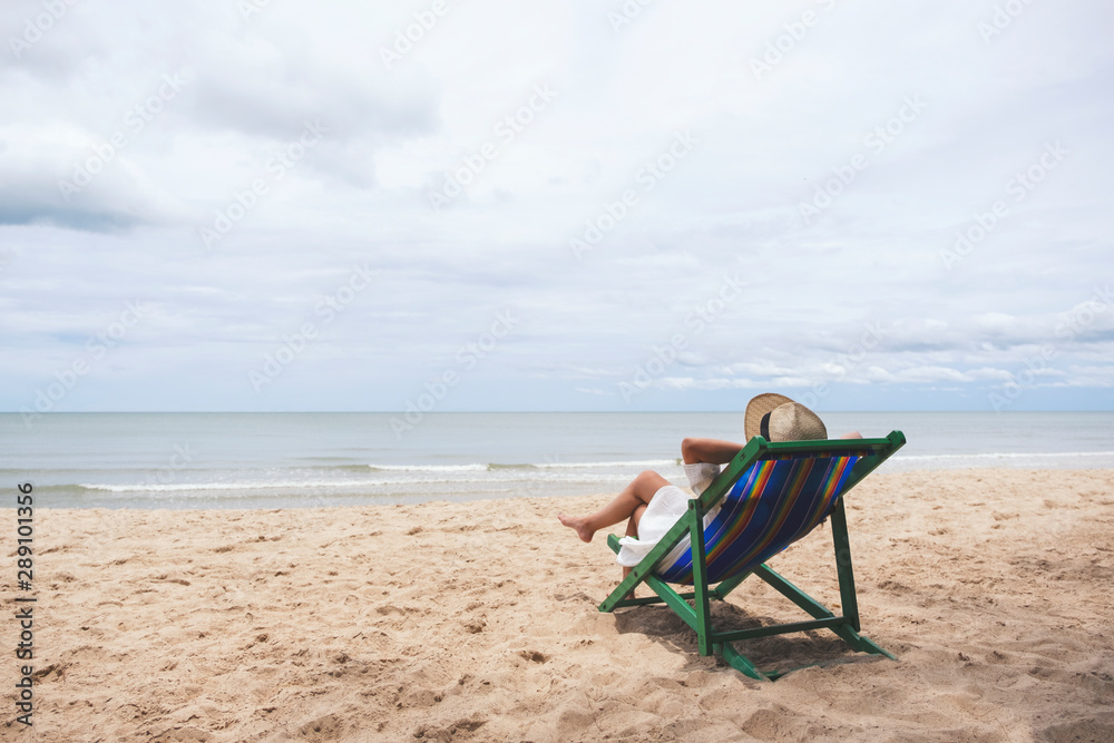A woman lying down on a beach chair with feeling relaxed