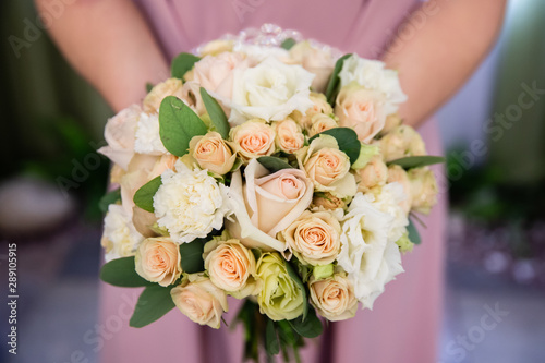 Beautiful wedding bouquet of flowers in the hands of the bride