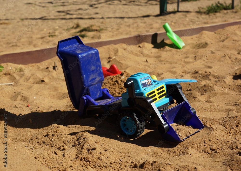 forgotten children's car in the sandbox forgotten children's car in the sandbox