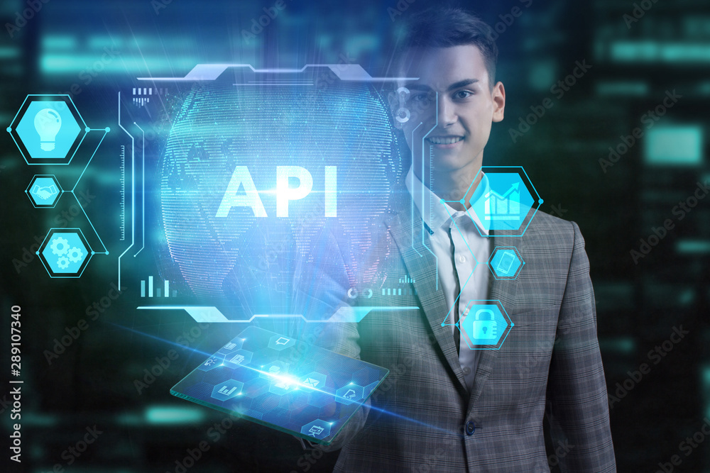 The concept of business, technology, the Internet and the network. A young entrepreneur working on a virtual screen of the future and sees the inscription: API The concept of business, technology, the Internet and the network. A young entrepreneur working on a virtual screen of the future and sees the inscription: API