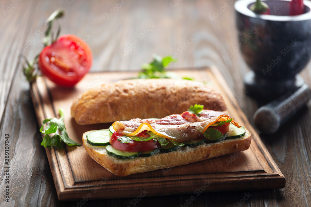 Delicious Sandwich with Bacon and Vegetables on a wooden board Delicious Sandwich with Bacon and Vegetables on a wooden board