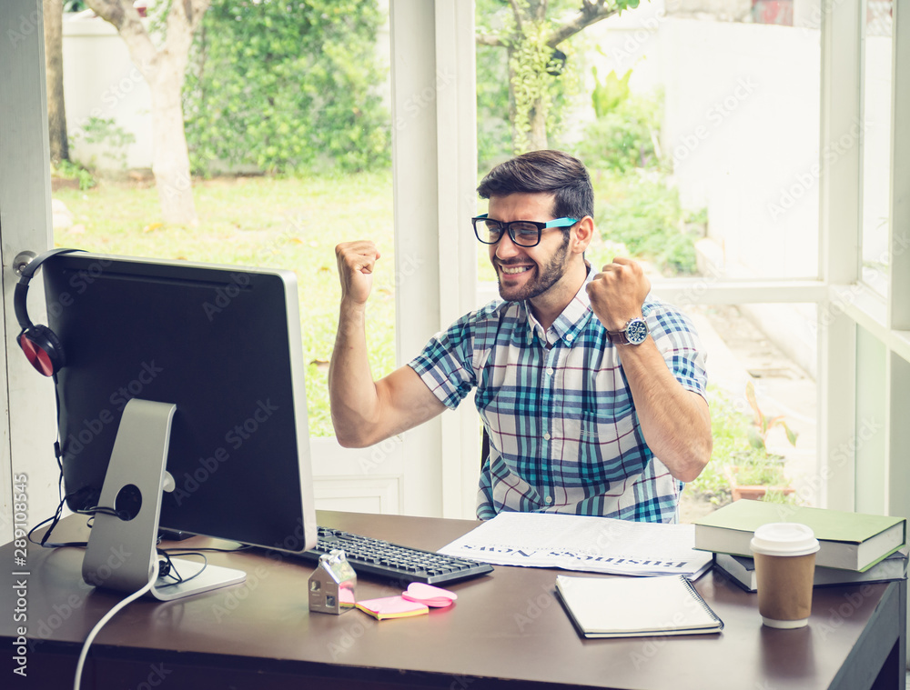 Casual young caucasian businessman at his desk in winning concept. Casual young caucasian businessman at his desk in winning concept.