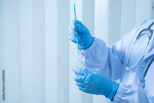 Doctor hand holding liquid base cytology set on blue background.Gynecologist working for vaginal and cervix pap smear patient in the obstetrics and gynecology department.Medical concept. photo