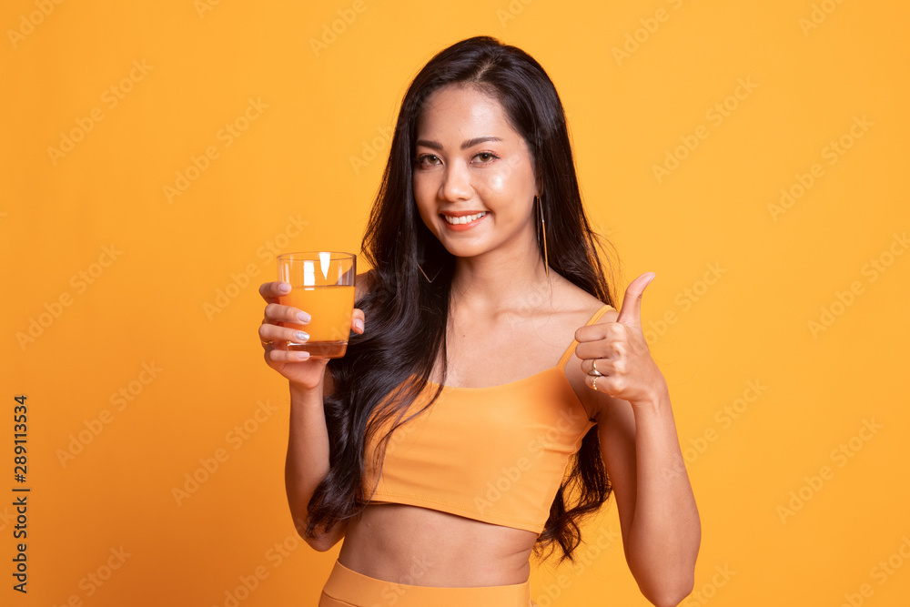 Young Asian woman thumbs up drink orange juice. Young Asian woman thumbs up drink orange juice.
