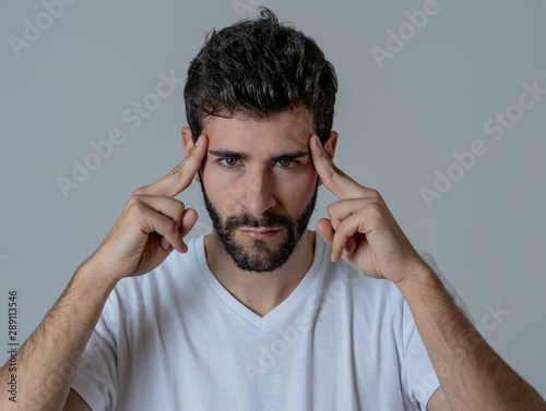 Portrait of sad man in pain having headache and migraines