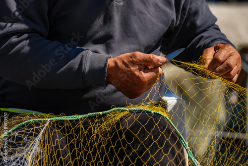 Close up detail of Fisherman's hand, repairing fishing net. Selective Focus.