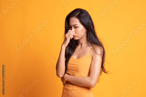 Young Asian woman holding her nose because of a bad smell.