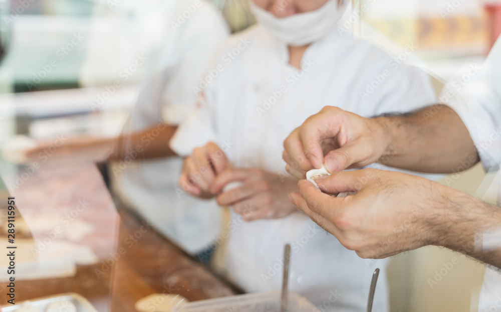 Close up hand of chef are make Xiao long bao.It is the most popular Chinese dim sum dishes. Xiao long bao is made from bread flour mixed with wheat flour with minced pork filled with broth in the wate