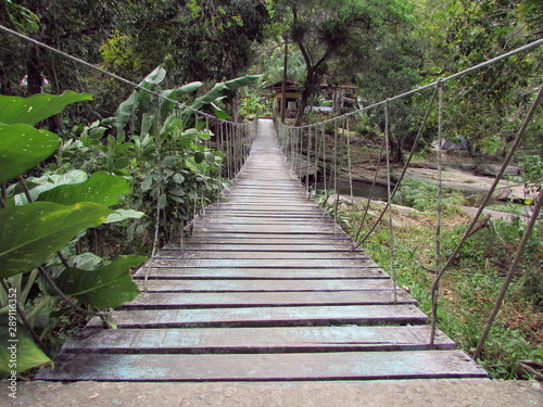 Old wooden suspension bridge over river water in Baturite, Ceara