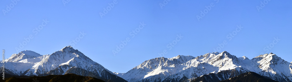 Panorama of mountain peaks with freshly fallen white snow.