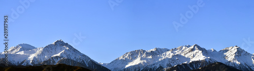 Panorama of mountain peaks with freshly fallen white snow.